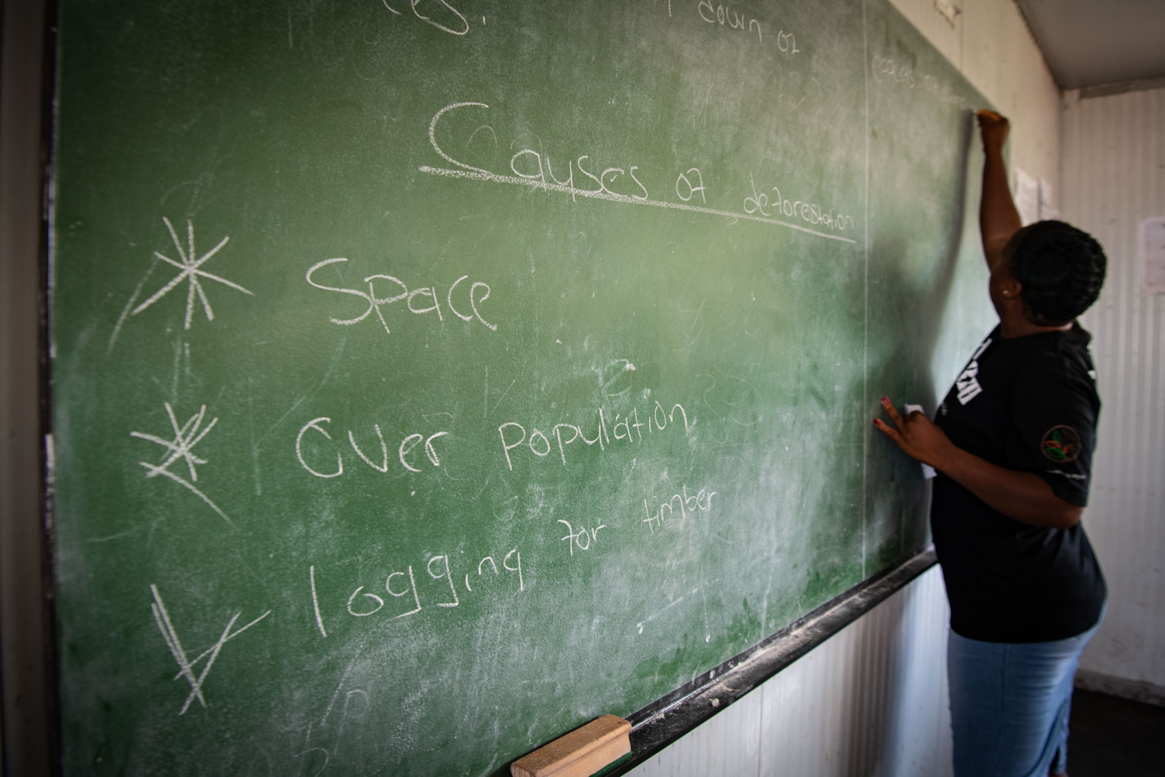 A teacher writes on a chalkboard in South Africa