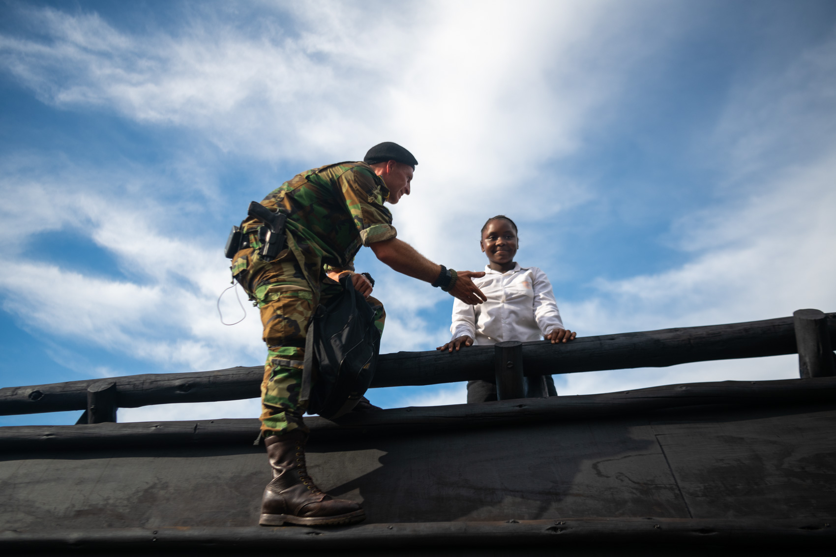 A Protrack Anti-Poaching Unit instructor helping a school girl over an obstacle